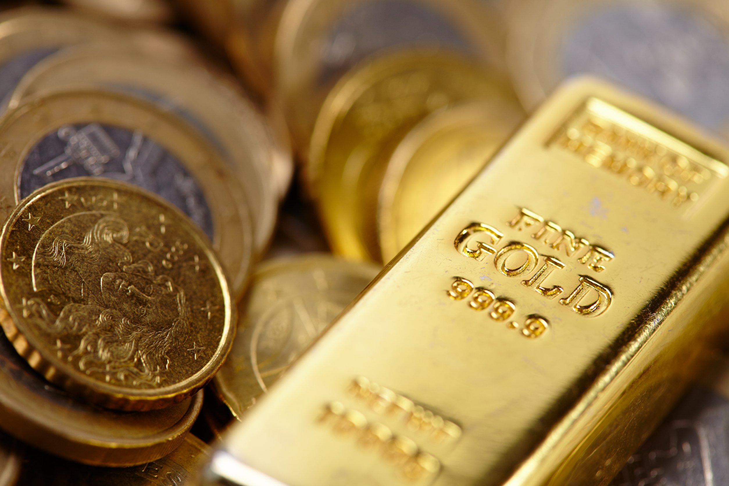 gold bar with coins Gold falls 0.6% after Fed Chair comments and ECB’s 75 bps rate hike